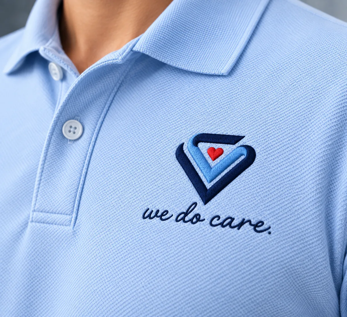Diamond Care Transportation dimensional logo sign on an office lobby wall and a light blue polo embroidered with the "we do care" heart logo